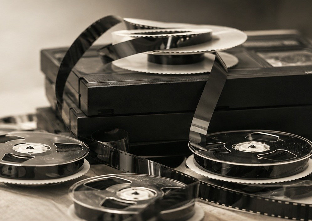 Filmruller, smalfilm og videokassetter på et bord